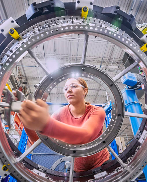 Color photo of female technician working in a peach shirt.