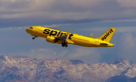 Photo of yellow airplane, a Spirit Airlines jet in the sky.